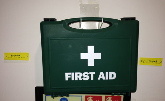 An image of a first aid kit on a wall surrounded by tags that say 'first aid' and '/first aid'